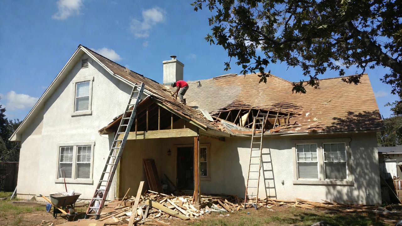 Texas house undergoing full roof repair with old shingles removed and new materials being installed 2026